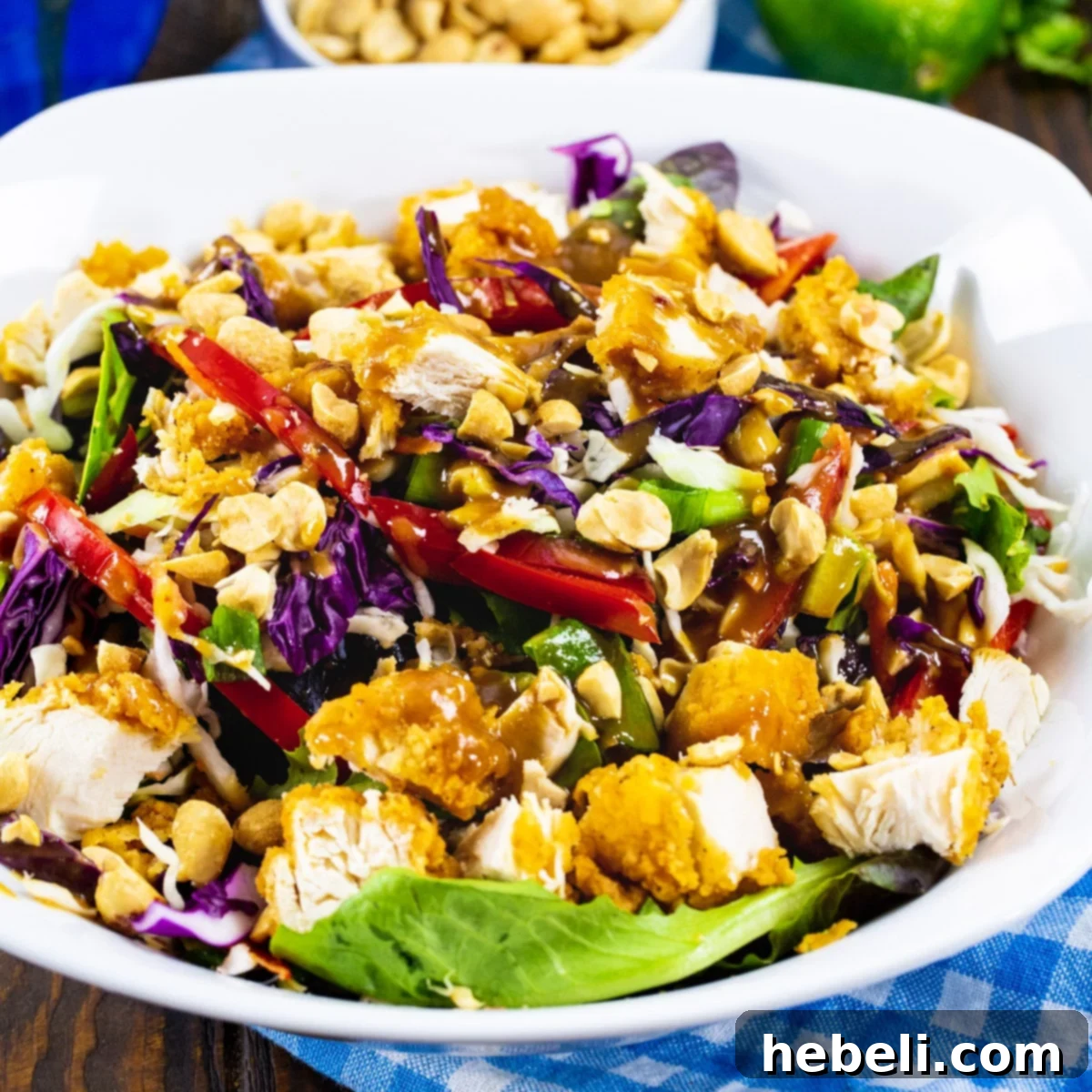 Chicken Tender-Peanut Chopped Salad in a large white bowl, garnished with peanuts and cilantro.