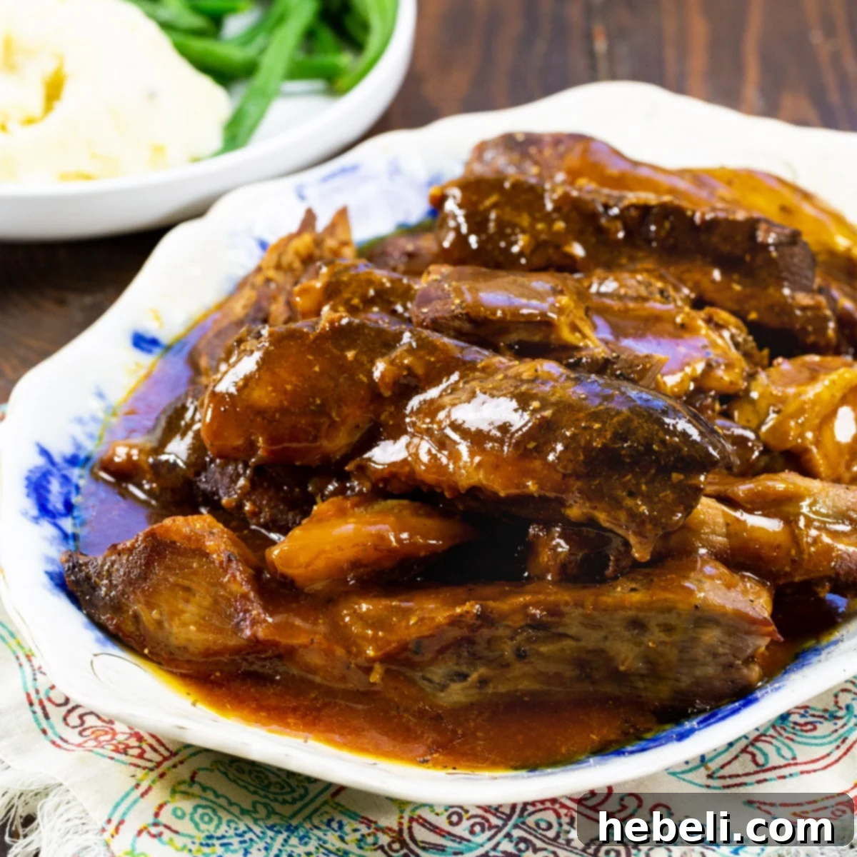 Slow Cooker Sweet and Sour Country Ribs on a platter, garnished with fresh herbs.