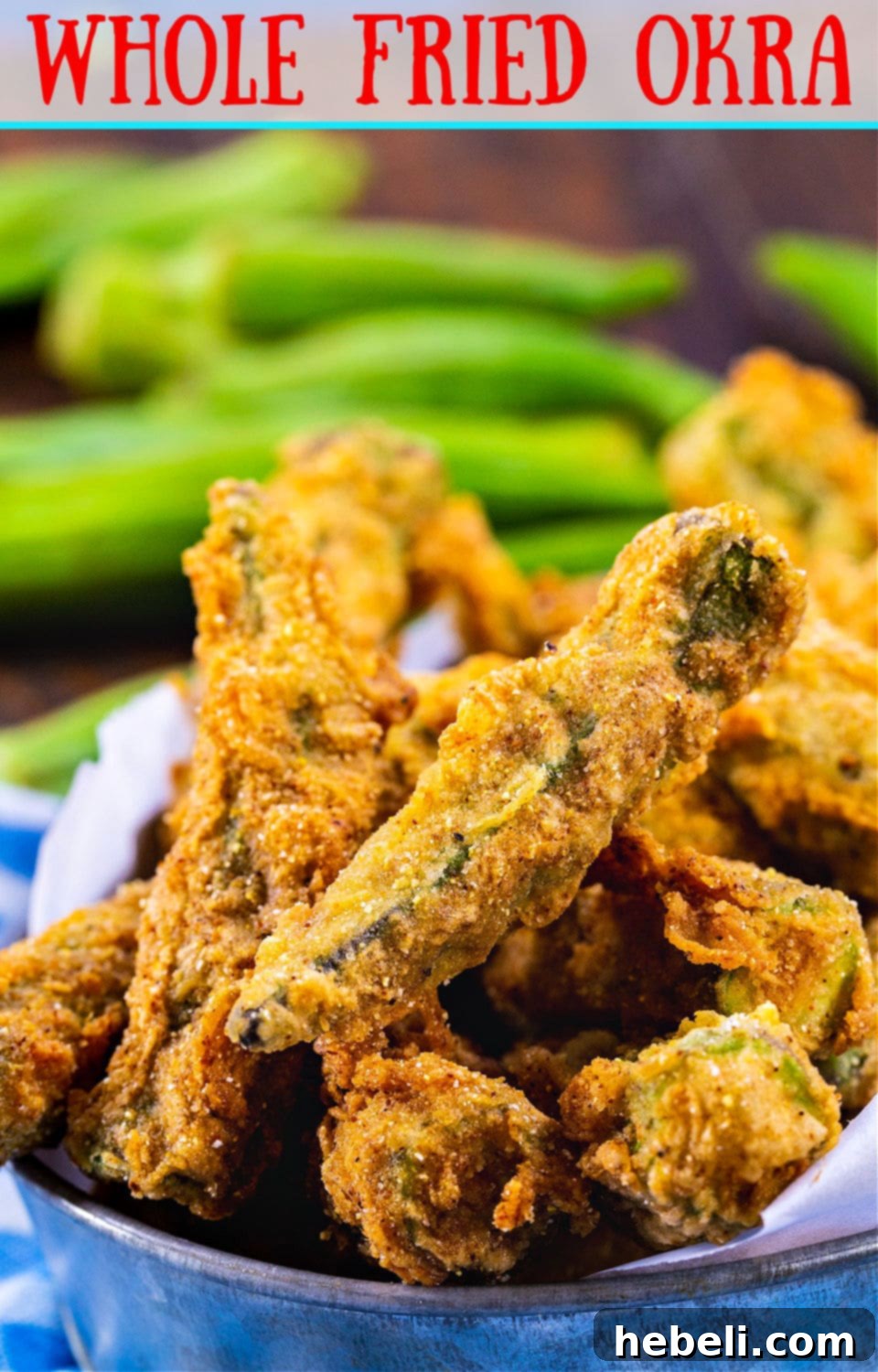 Close-up of golden, crispy Whole Fried Okra in a metal tin, with a dipping sauce in the background.