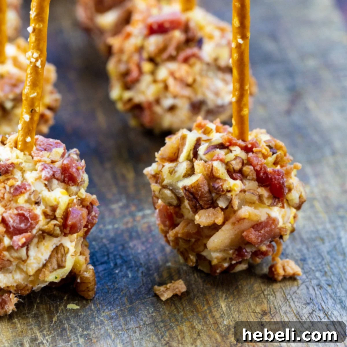 Bacon Cheese Ball Delights 2 Bacon Cheese Ball Bites with pretzels stuck in them, ready to be served.