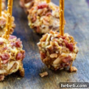 Bacon Cheese Ball Delights 5 Bacon Cheese Ball Bites with pretzels stuck in them.