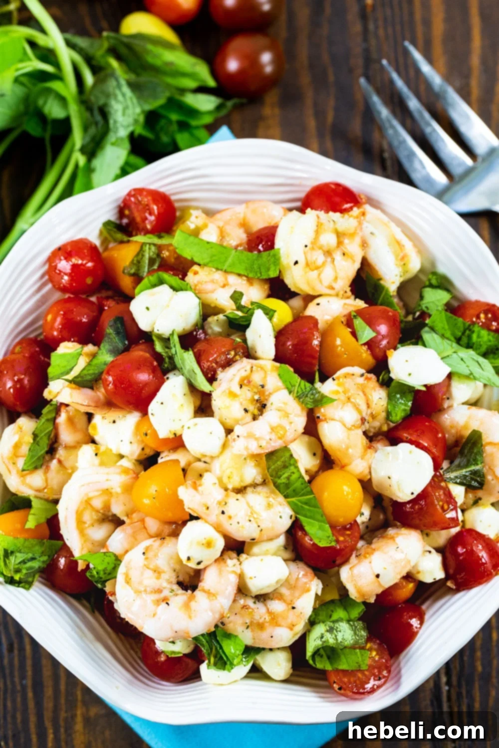 Marinated Shrimp Salad topped with fresh basil in white bowl, ready to serve.