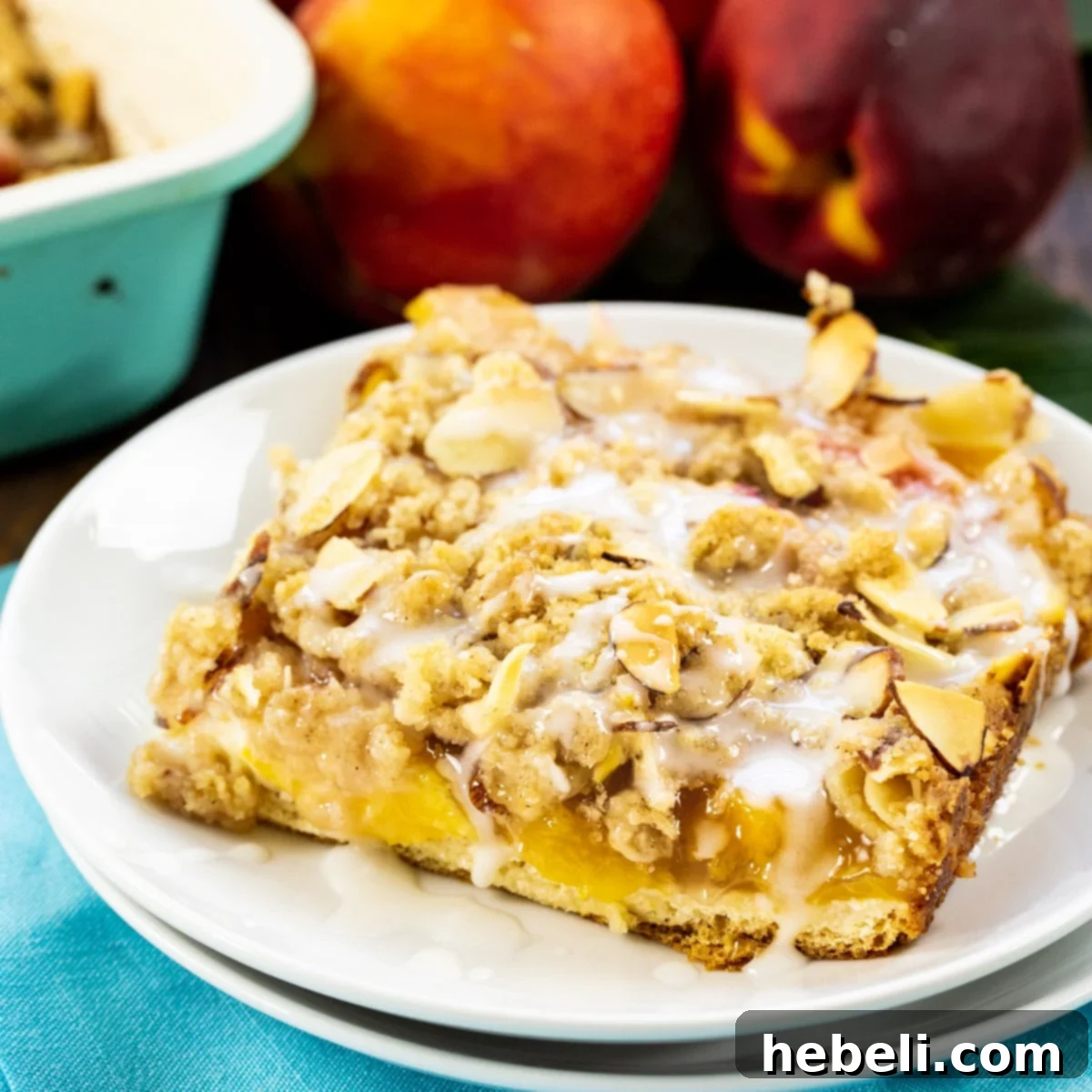 Luscious Peach Cream Crescent Bars 2 A slice of Peaches and Cream Crescent Bar on a white plate, showcasing its layers.