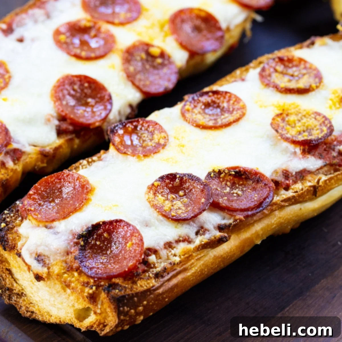 Two Pieces of Pepperoni French Bread Pizza on a cutting board, garnished with fresh basil.