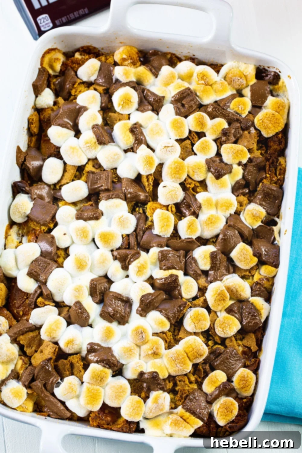 S'mores-style bread pudding presented in a 9x13-inch baking dish, adorned with chocolate, marshmallows, and graham crackers, ready to be enjoyed.