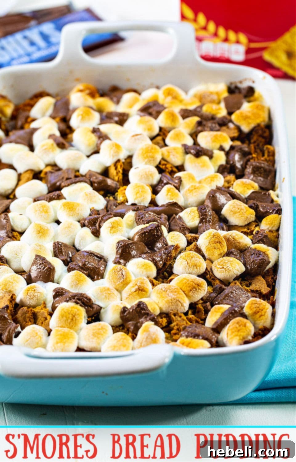 A top-down view of the S'mores Bread Pudding, showcasing the generous topping of melted milk chocolate, toasted mini marshmallows, and crunchy graham cracker crumbs, ready to be served.