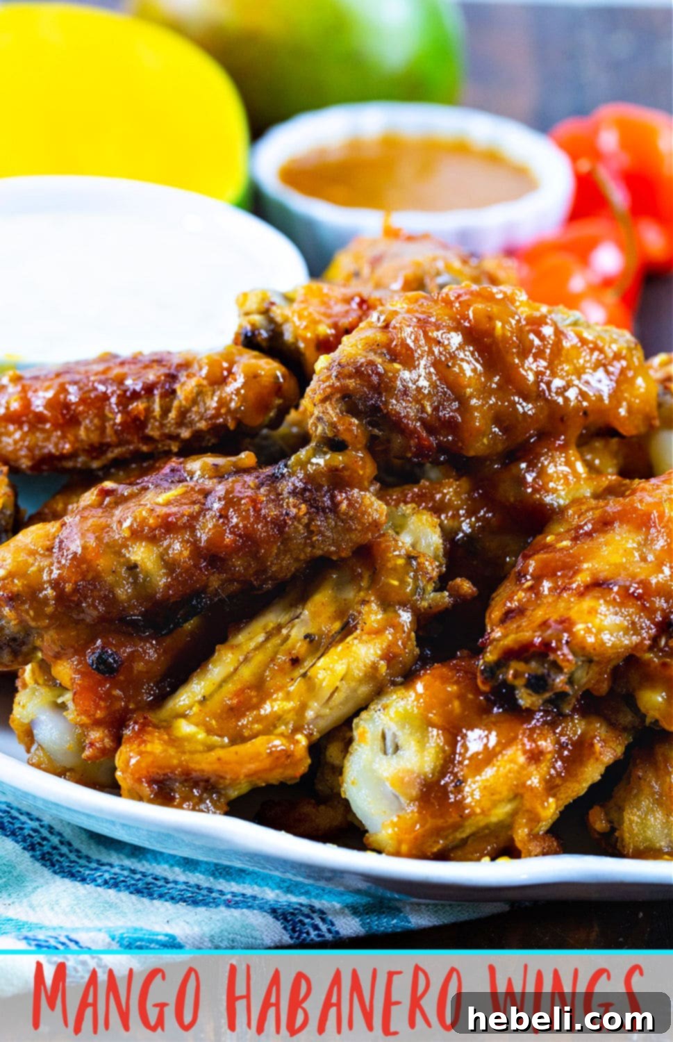 Sweet Heat Mango Habanero Wings 6 Beautifully glazed Mango Habanero Chicken Wings ready to be enjoyed, with vibrant ingredients in the background suggesting their fresh, homemade quality.