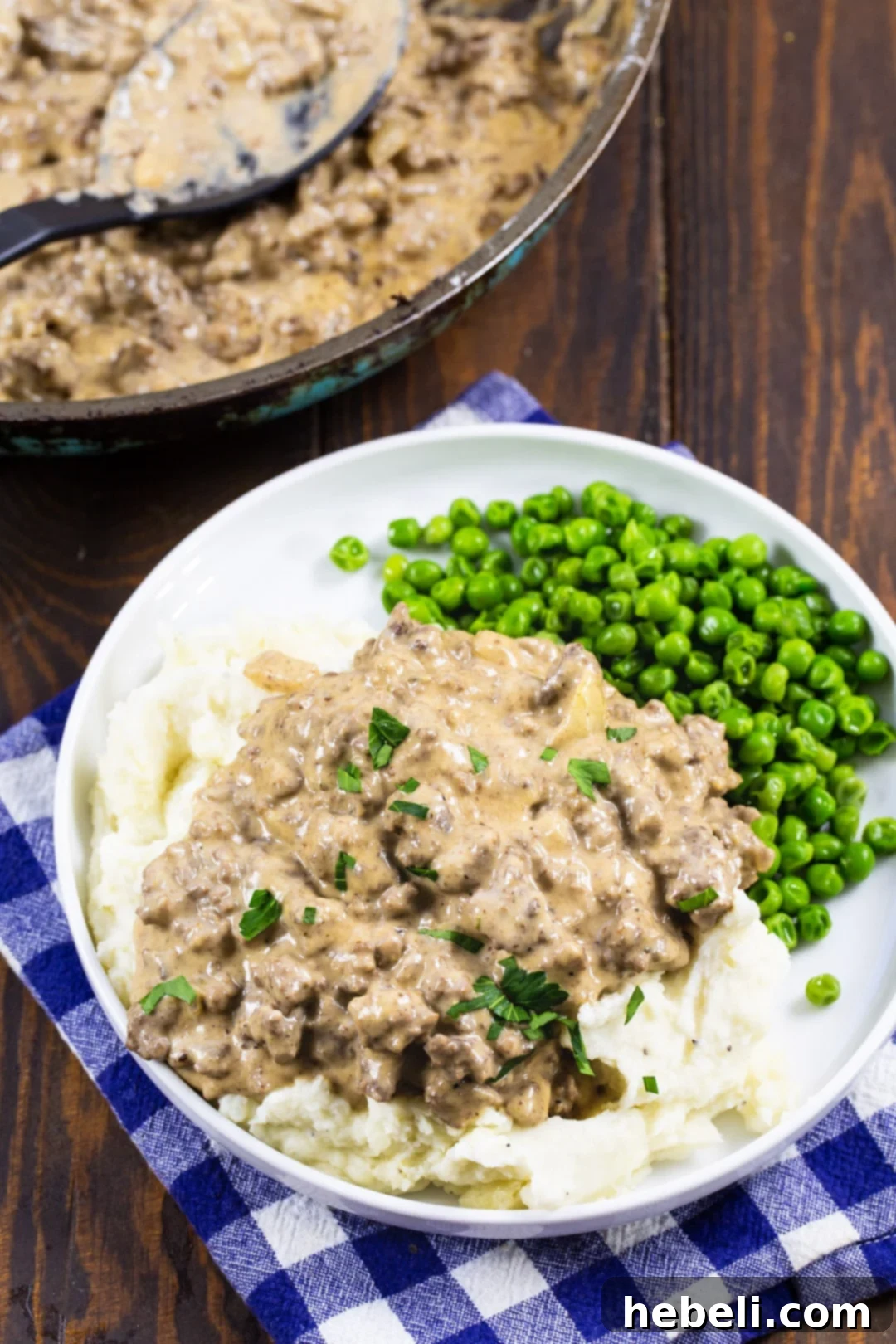 Ground Beef Gravy served over mashed potatoes with green peas, highlighting a complete comfort food meal.