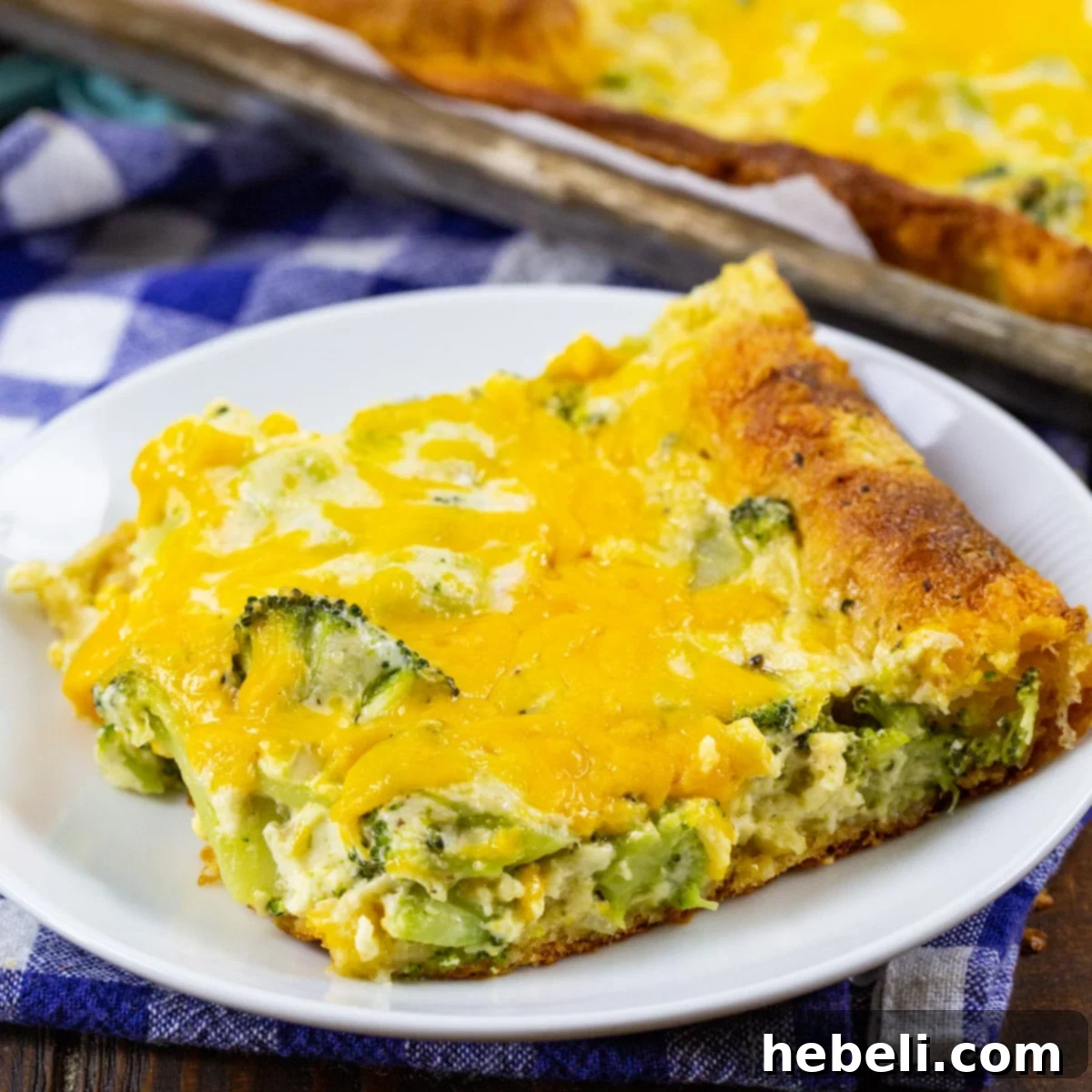 A single Broccoli Crescent Square on a small plate, showcasing the cheesy broccoli topping and golden crust.