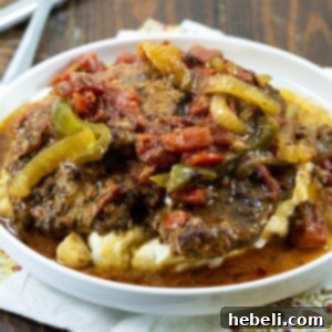 A top-down view of Slow Cooker Swiss Steak, featuring a generous serving of tender beef in rich sauce, perfect for a family meal.