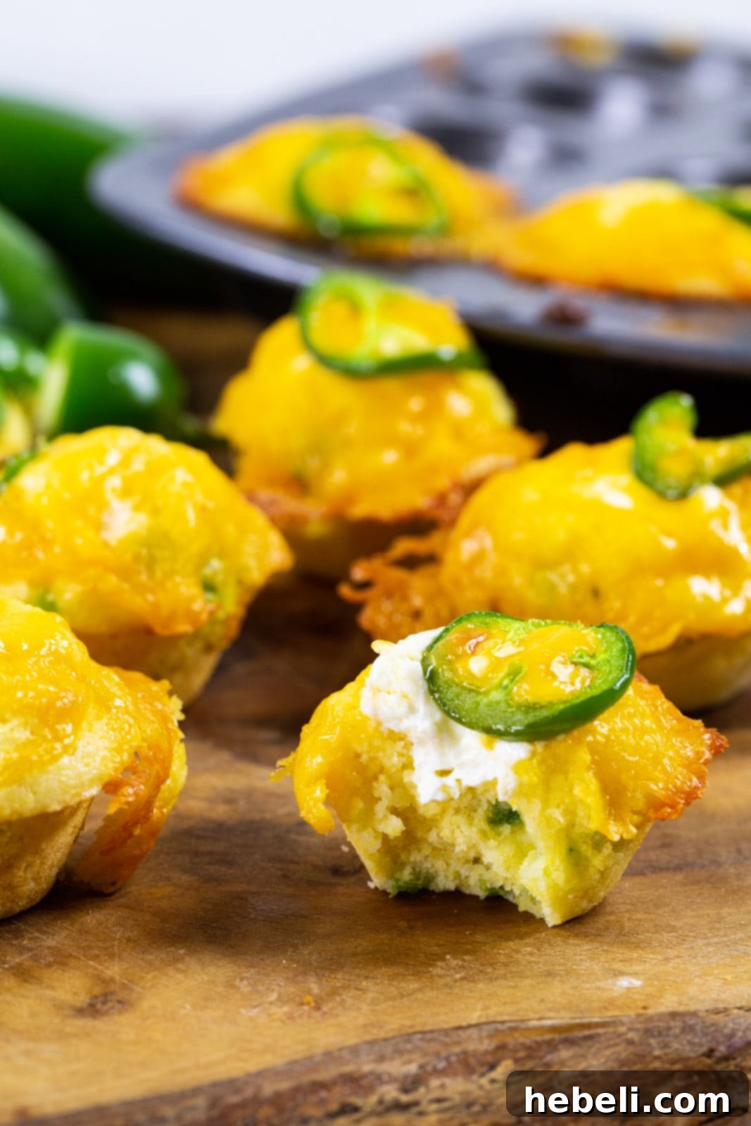 Jalapeno Cornbread Poppers 4 Jalapeno Popper Corn Muffins with bite taken out of one.
