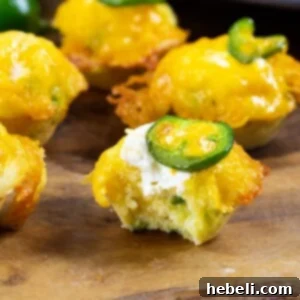 Jalapeno Cornbread Poppers 5 Jalapeno Popper Corn Muffins with bite taken out of one to show inside.