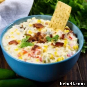 Zesty Cheesy Slow Cooker Corn Dip 4 A top-down view of the prepared Slow Cooker Jalapeno Popper Corn Dip in a smaller serving bowl, showcasing its rich texture and topping of bacon and cilantro.