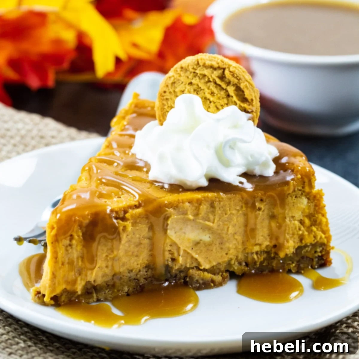A delectable slice of Pumpkin Cheesecake, adorned with a swirl of whipped cream and a generous drizzle of homemade salted caramel sauce, ready to be enjoyed.