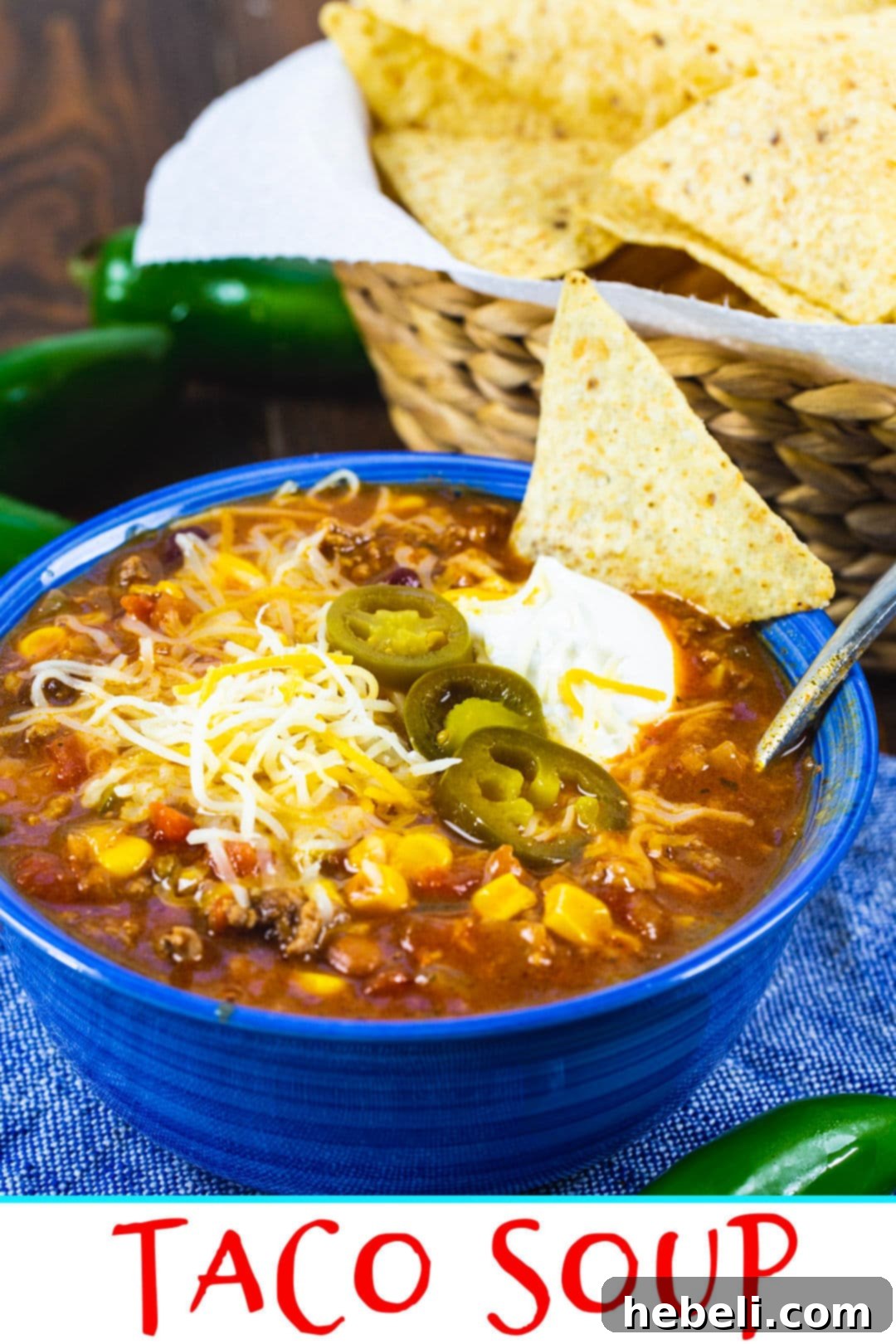 A close-up shot of steaming Taco Soup in a rustic blue bowl, garnished with melted cheese and fresh herbs, ready to be enjoyed.