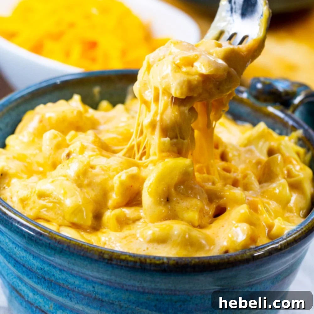 Ultimate Mac and Cheese Creations 15 A fork scooping up Slow Cooker Ultra Creamy Mac and Cheese, highlighting its rich, gooey, and smooth texture.