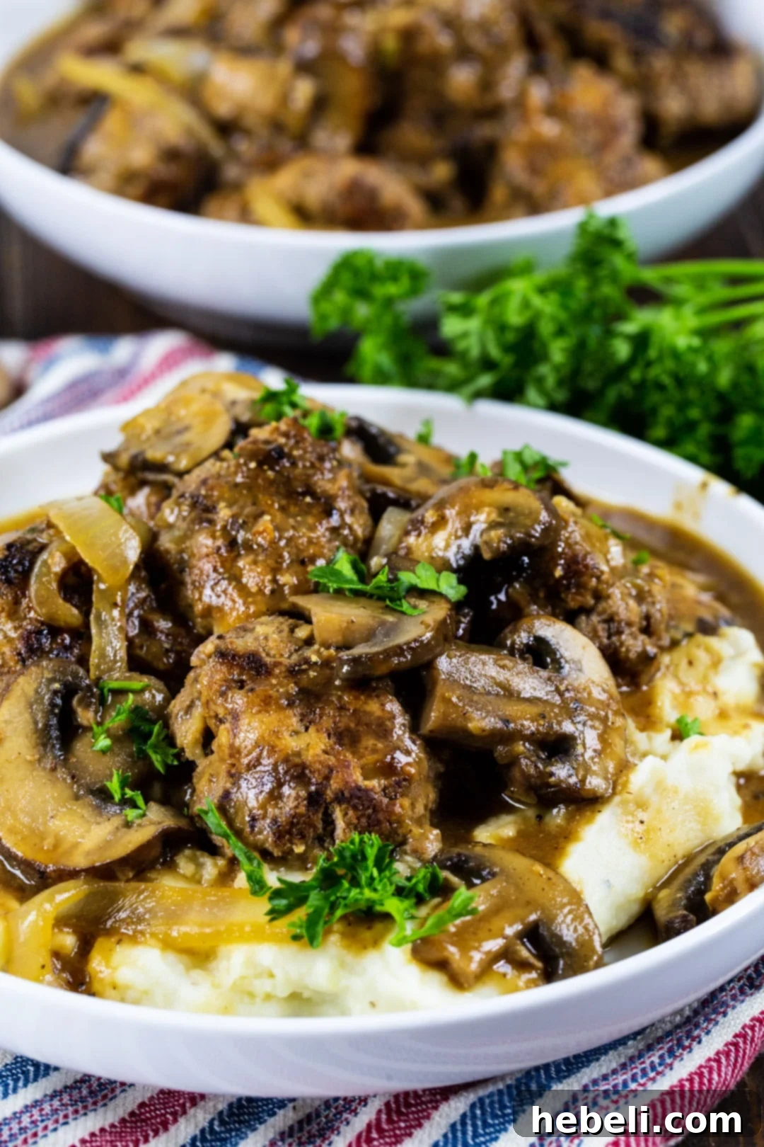 A plate of Meatloaf Meatballs with Brown Gravy, perfectly portioned over mashed potatoes, ready to be enjoyed.