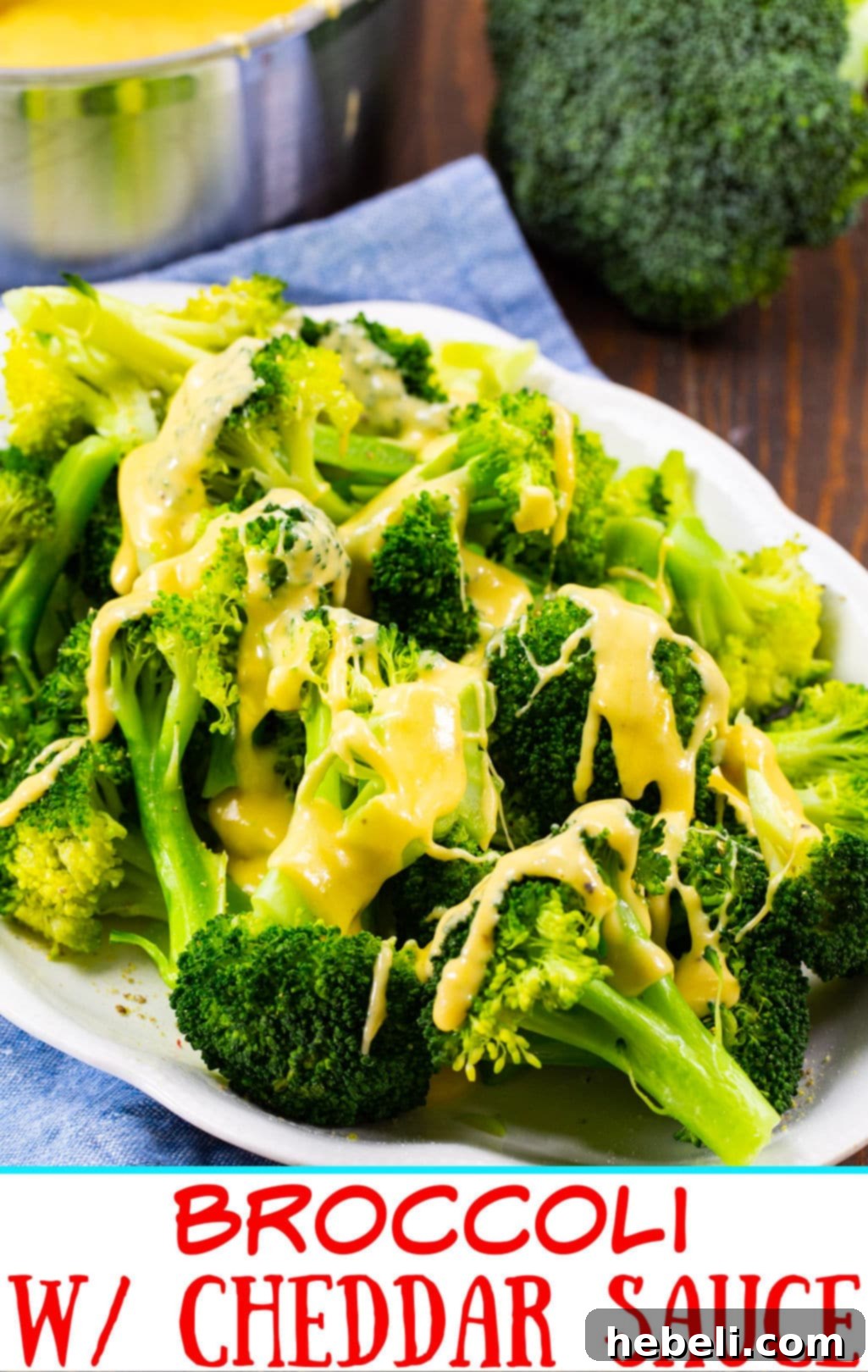 Close-up of a serving plate filled with perfectly steamed broccoli florets generously coated in a golden, creamy cheddar cheese sauce.