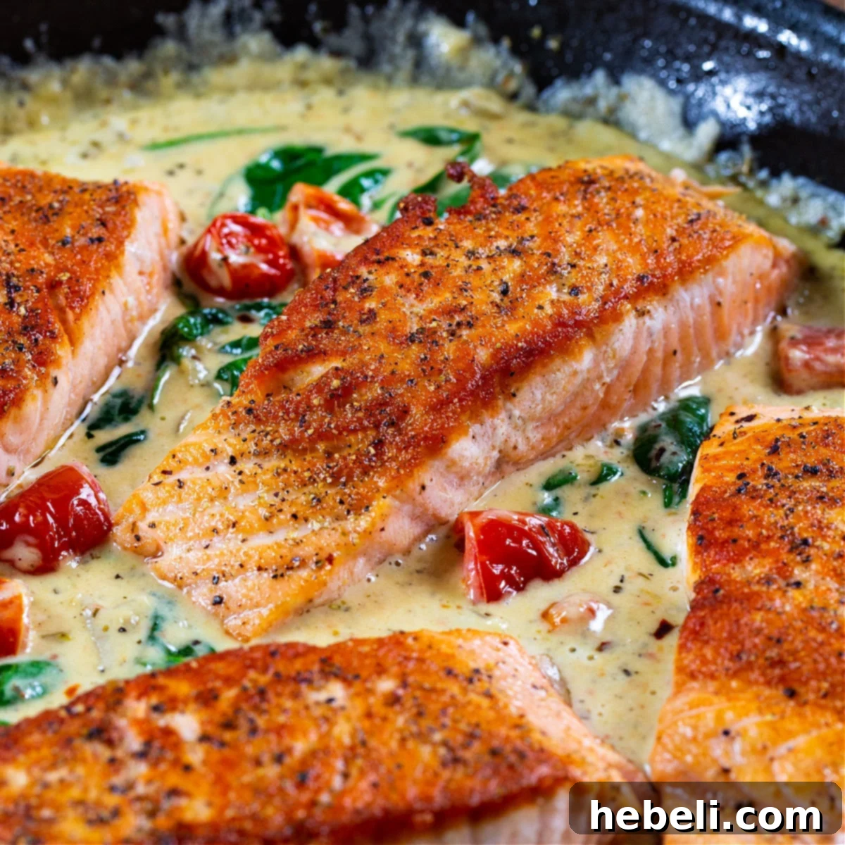 Creamy Tuscan Salmon in a skillet, beautifully garnished with fresh basil.