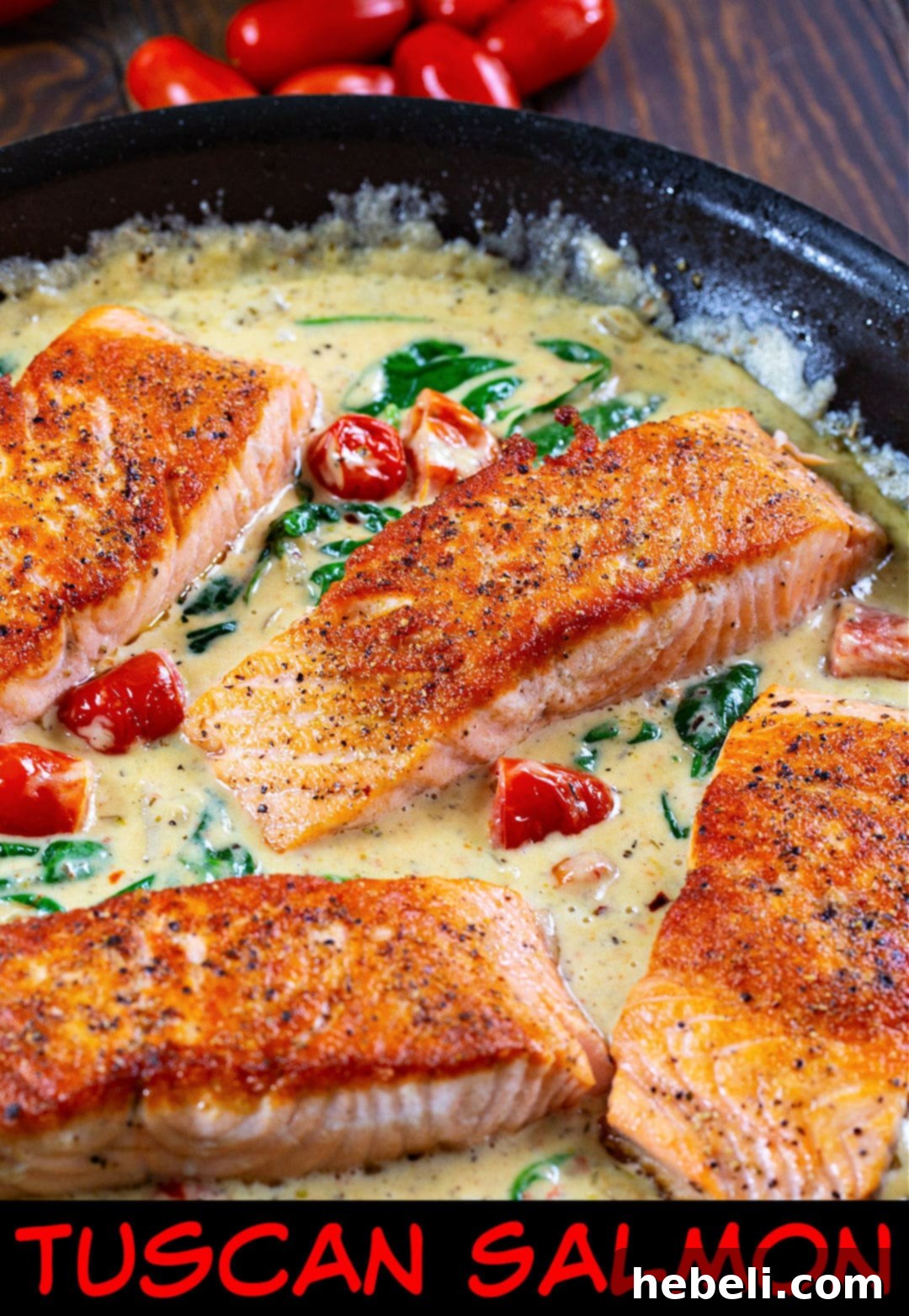 Tuscan Salmon fillets sizzling in a skillet with creamy sauce, garnished with fresh herbs.