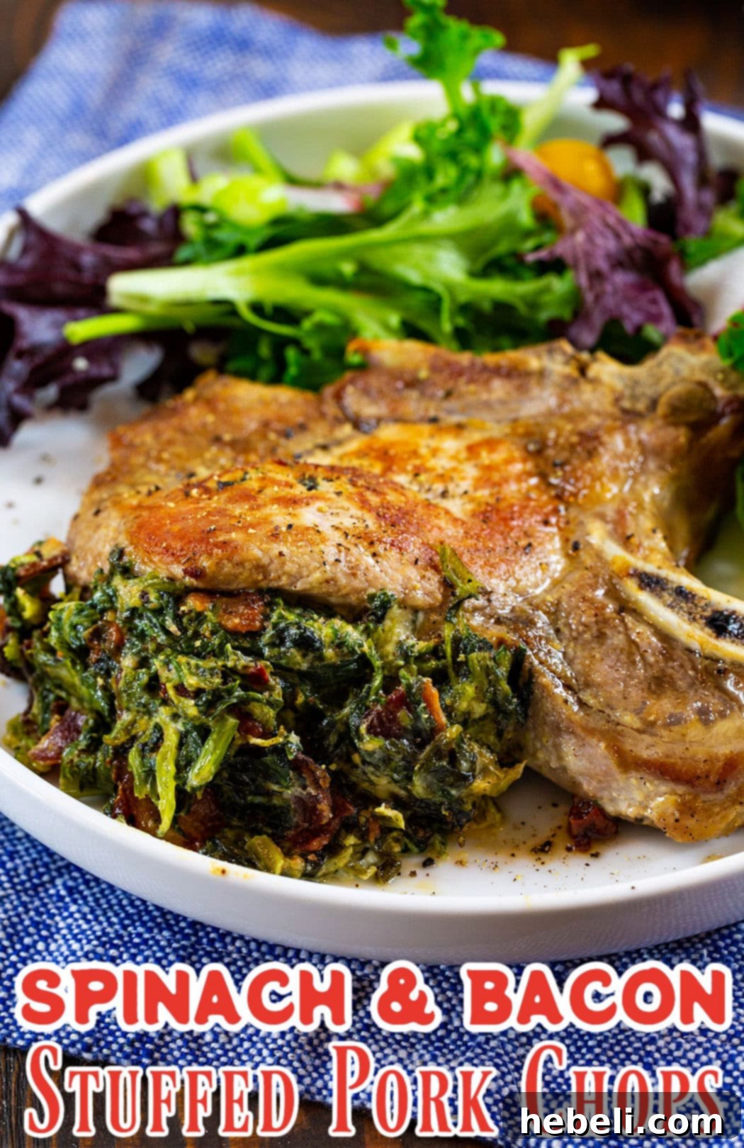 Close-up shot of a Spinach and Bacon Stuffed Pork Chop with a creamy filling visible, served with a side of green vegetables.