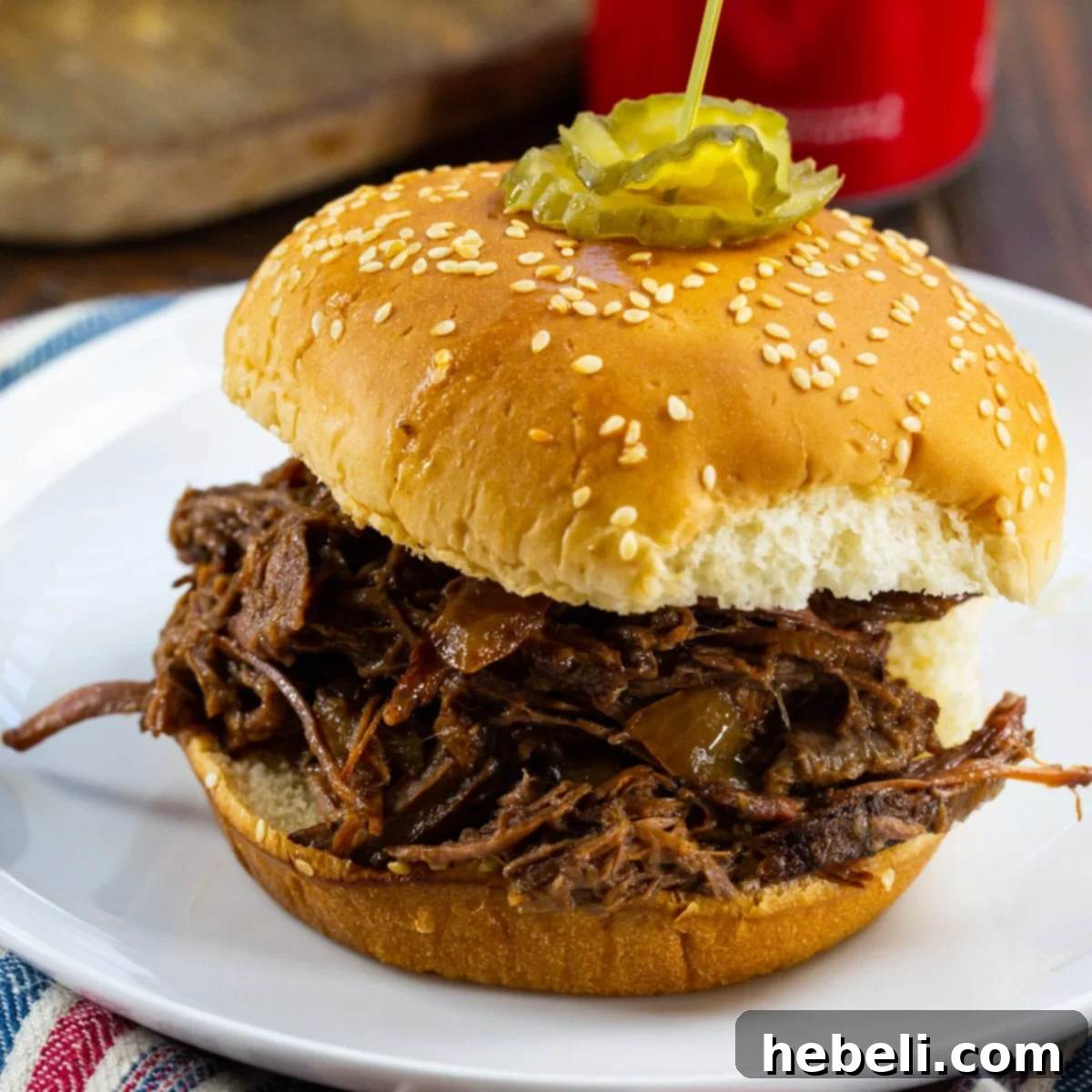 Slow Cooker BBQ Beef on a bun, topped with coleslaw.