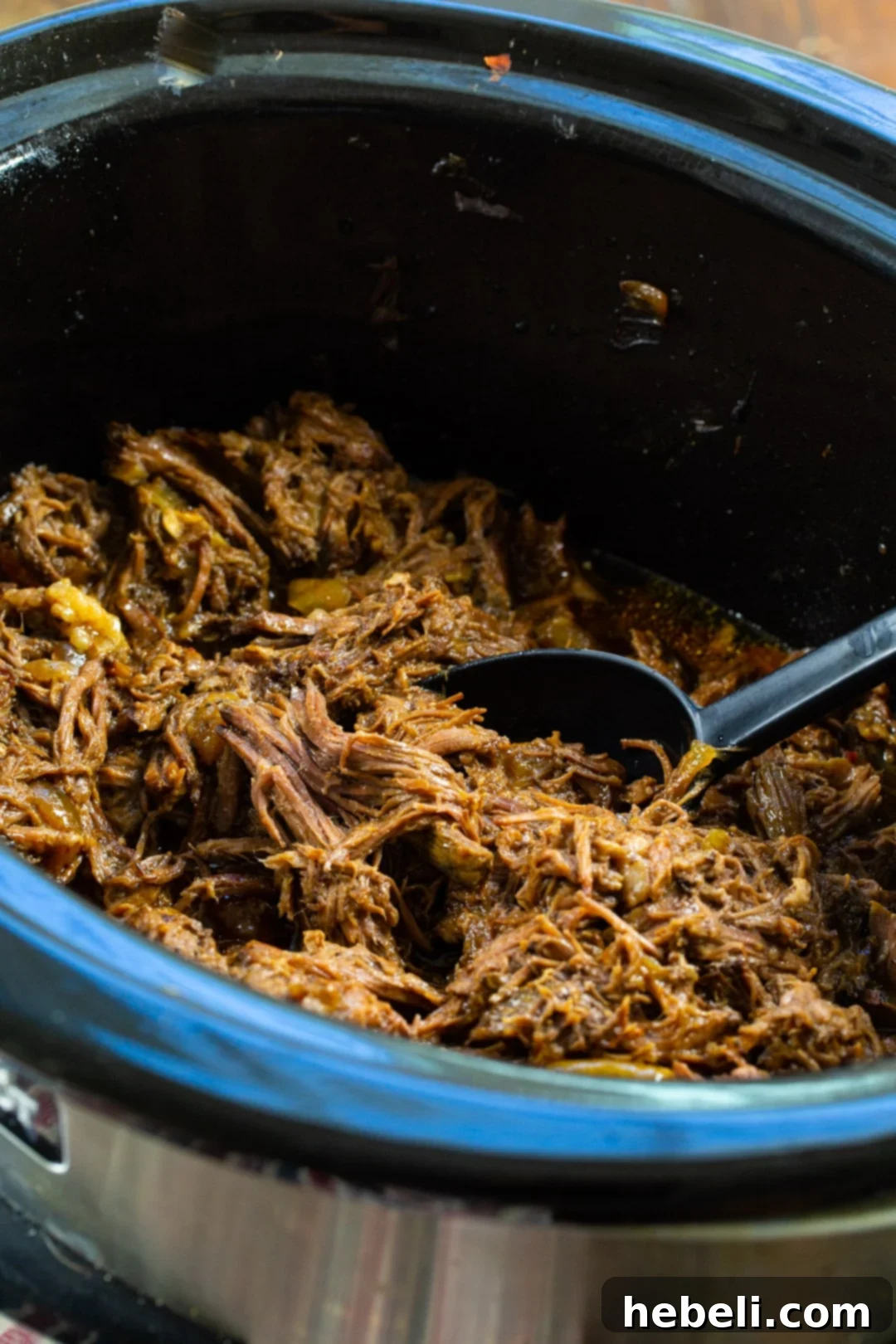 BBQ Beef cooking in a slow cooker with onions and liquids.