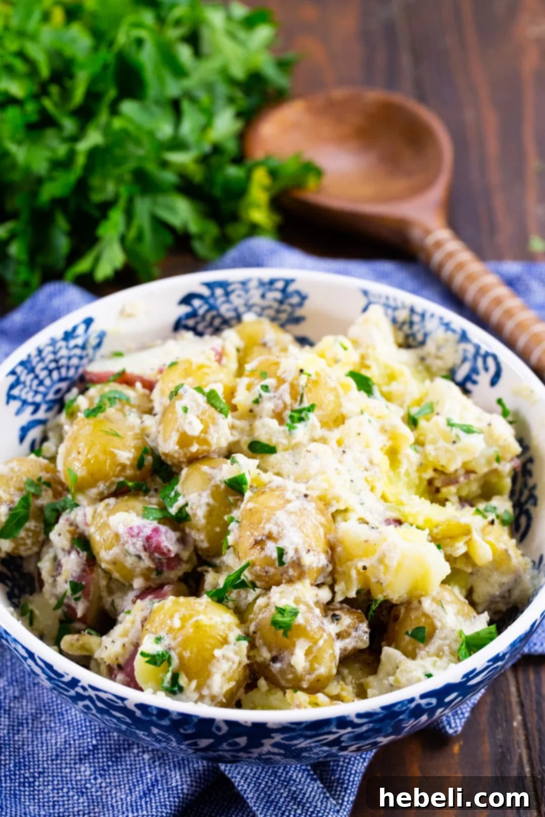 A bowl of freshly prepared new potatoes, garnished with fresh green herbs, ready to be served.