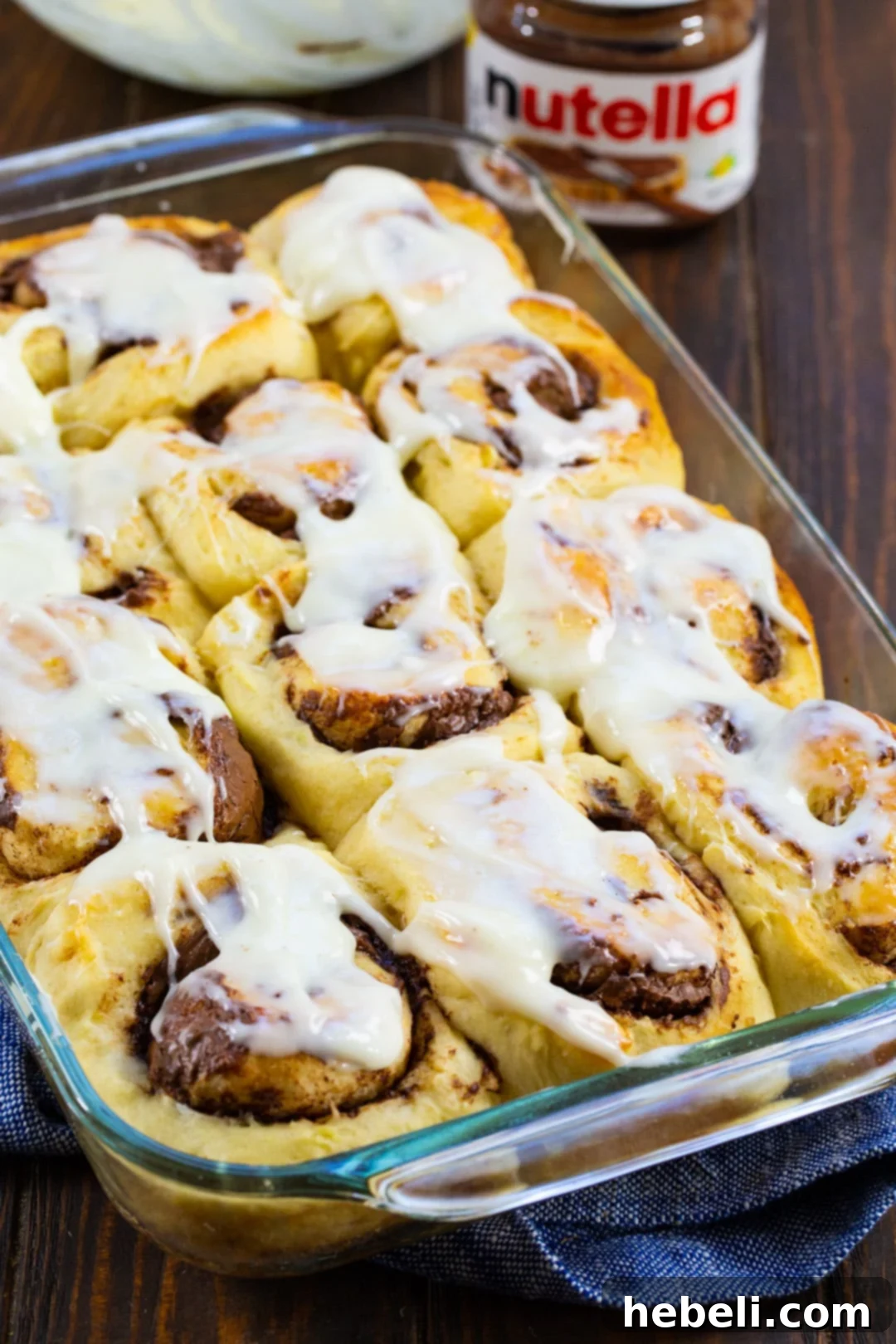 Luscious Nutella Cinnamon Buns 3 Freshly baked Nutella Cinnamon Rolls arranged neatly in a 9x13 inch baking dish, ready to be glazed.