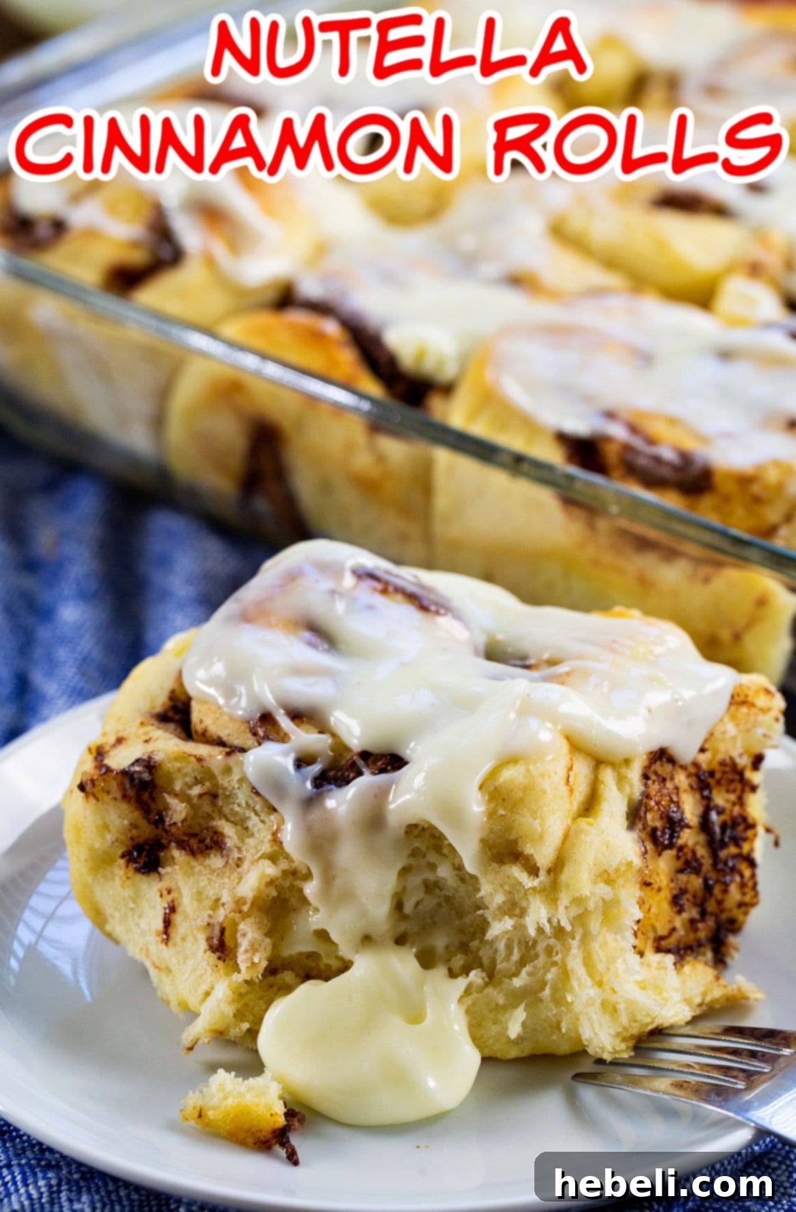 Luscious Nutella Cinnamon Buns 4 A single Nutella Cinnamon Roll on a small plate, with its rich, swirled filling and generous cream cheese glaze.