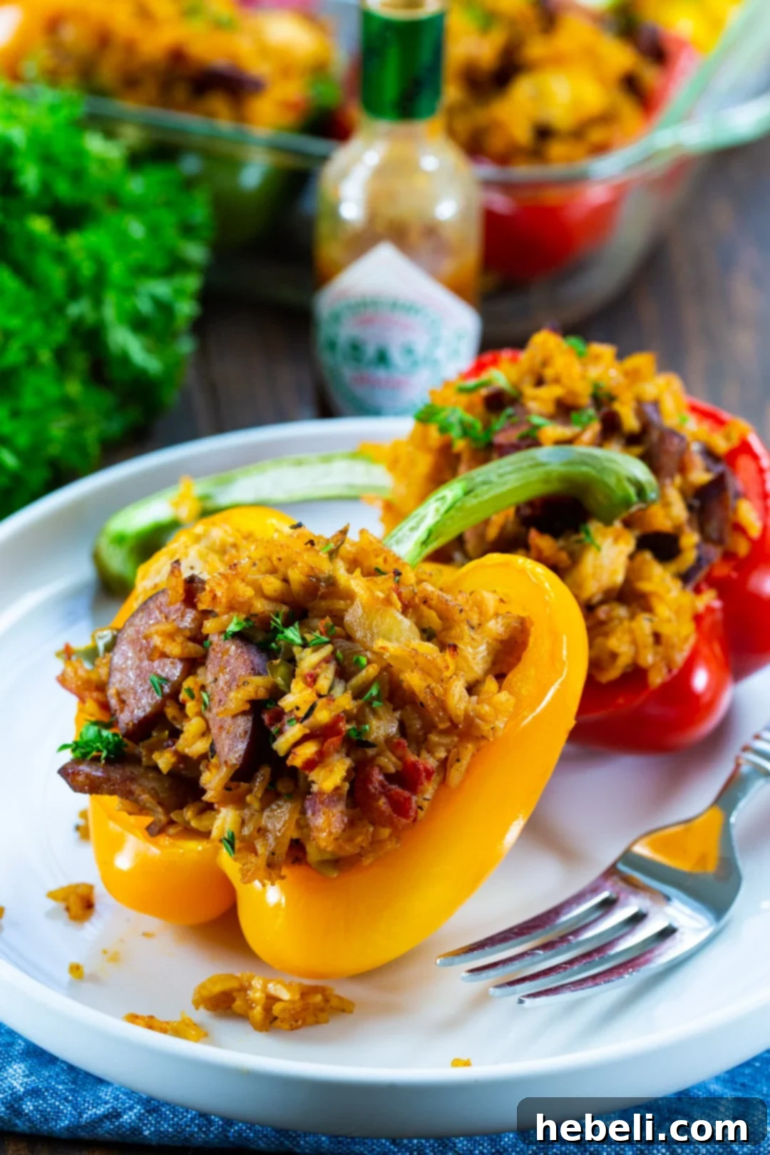 Cajun Jambalaya Stuffed Peppers 4 Two richly filled stuffed peppers resting on a plate, garnished with fresh herbs.