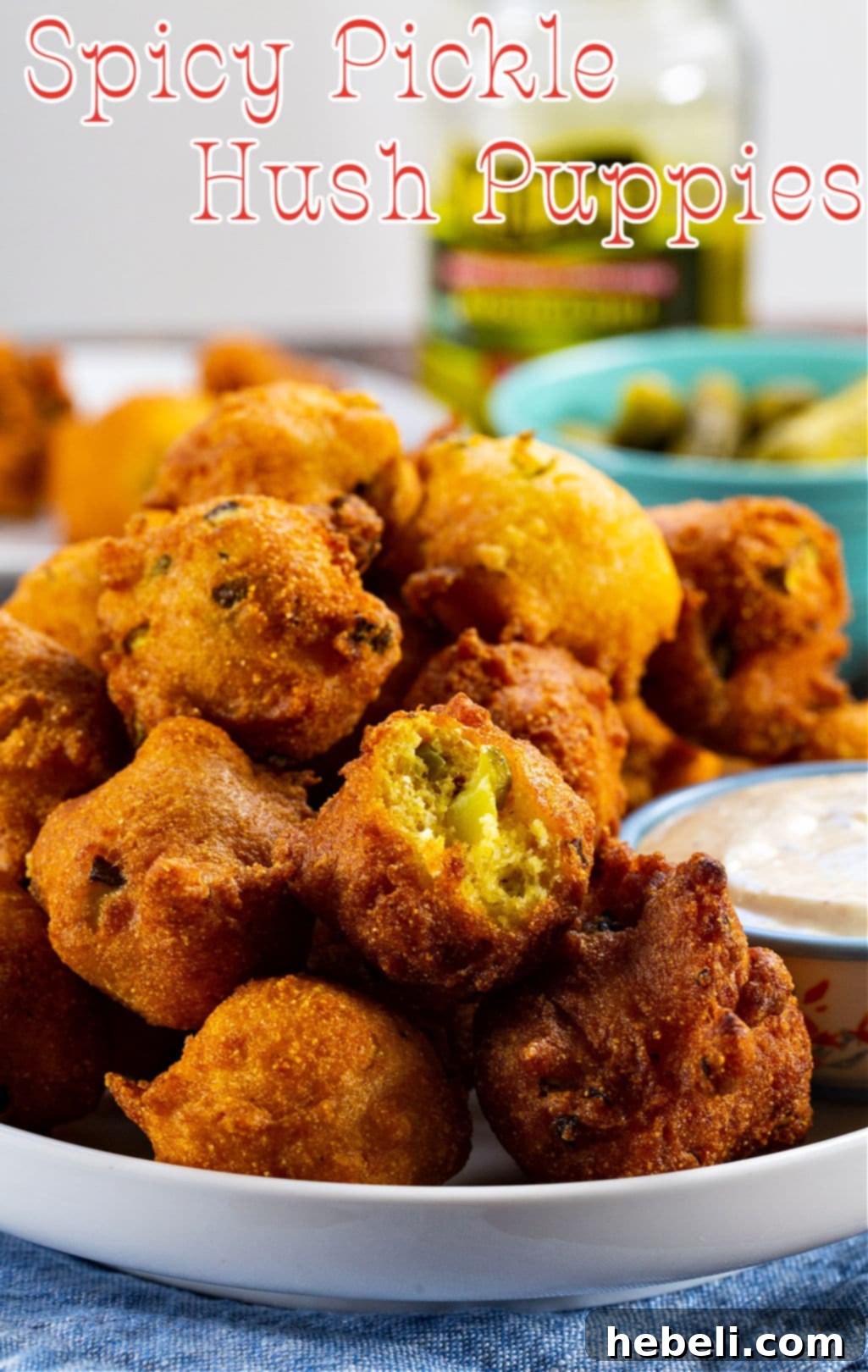 Piquant Pickle Hush Puppies 4 Close-up of a plate of Spicy Pickle Hush Puppies, one with a bite taken out, showing the soft interior with visible pickle pieces and a crispy exterior.
