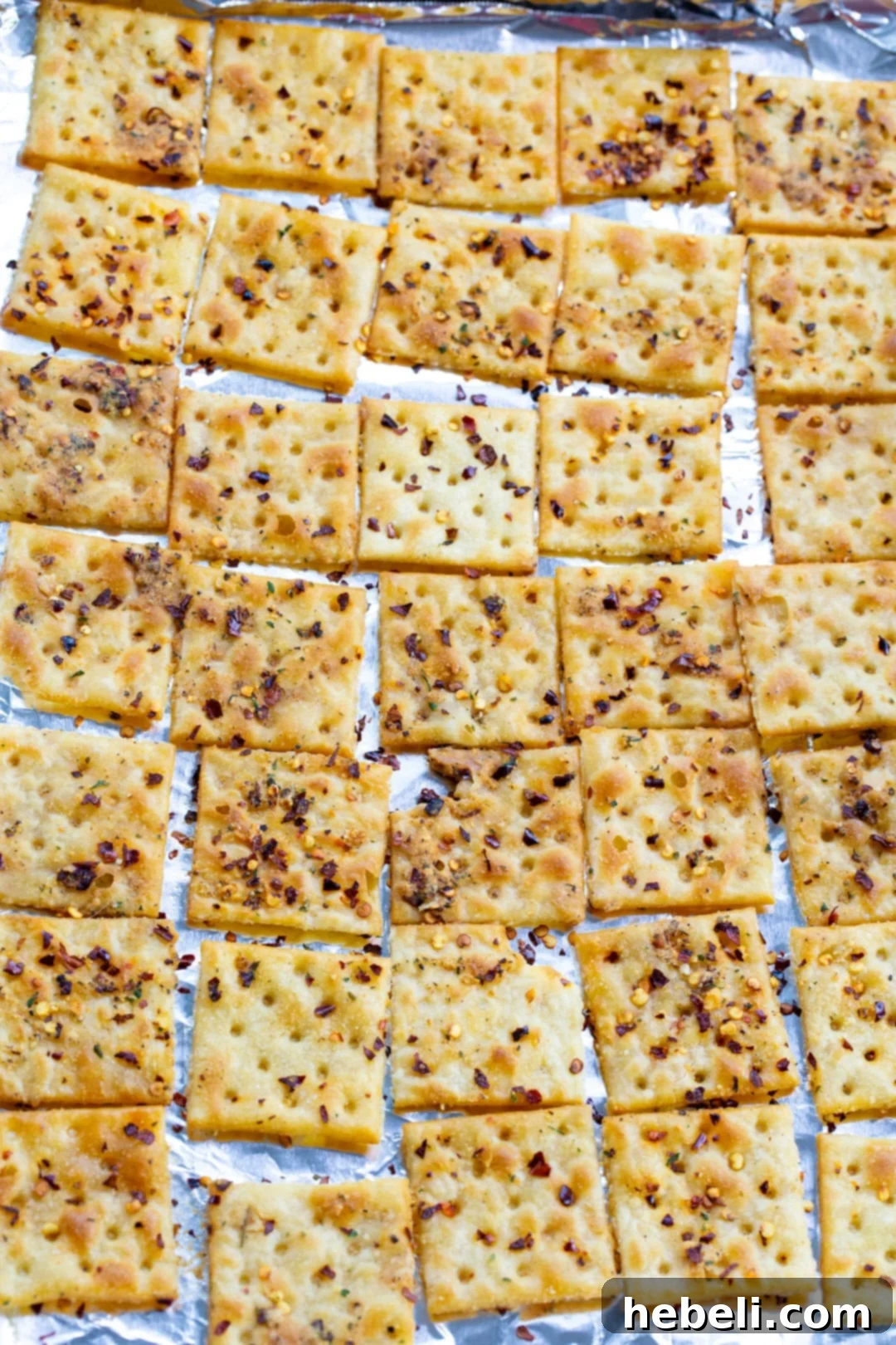 Saltine crackers laid out in a single layer on a baking sheet, ready for baking.