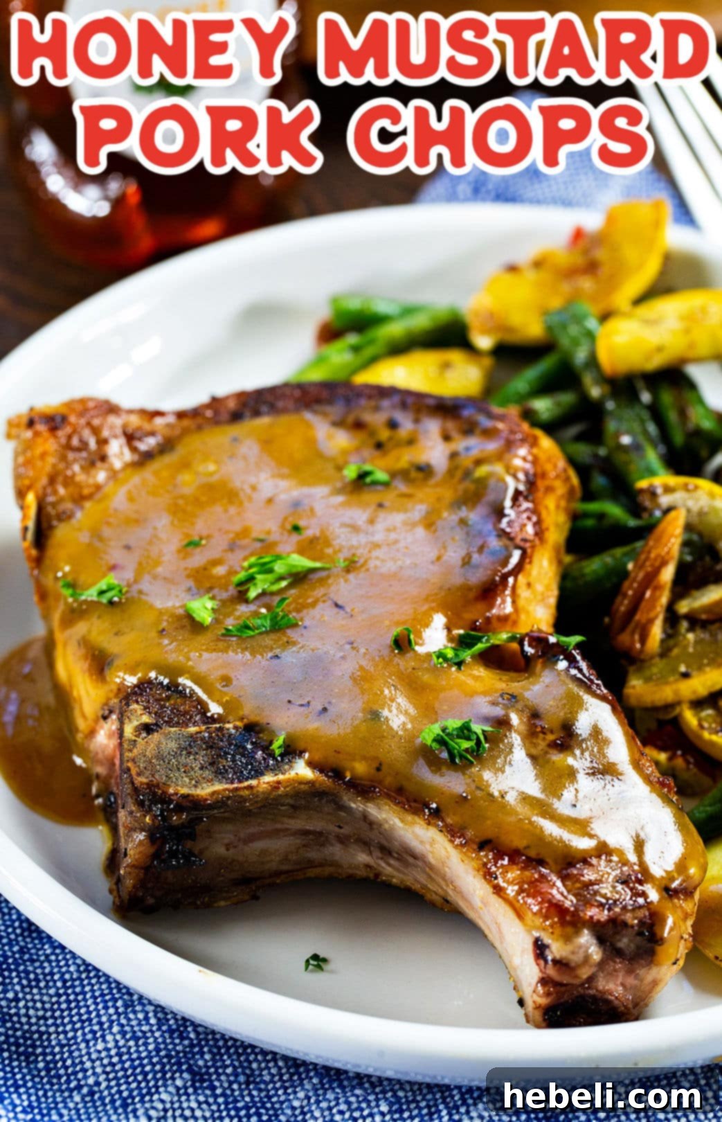 Glazed Honey Mustard Pork Chops 4 Honey Mustard Pork Chop on a plate with fresh green beans and squash, ready to be enjoyed.