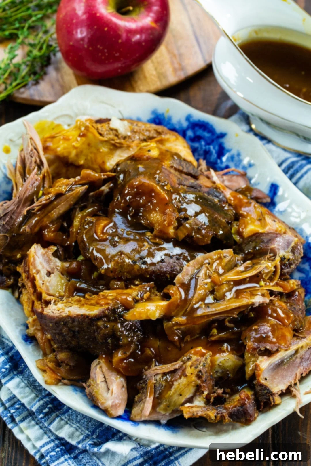 Apple Cider Pork Perfection 3 Apple Cider Pork pulled into succulent pieces with apple slices and gravy in background.