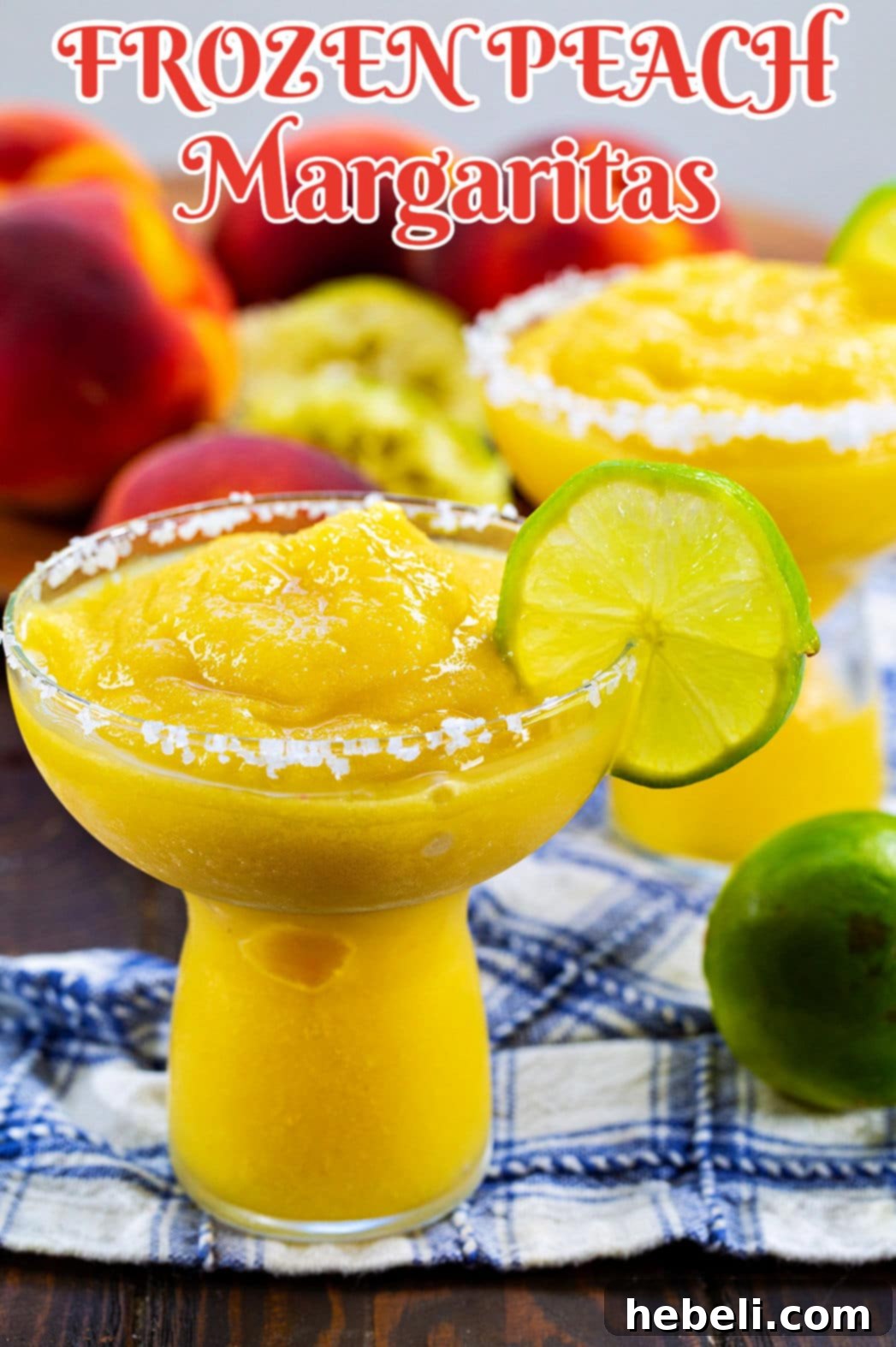 Three Frozen Peach Margaritas arranged artfully with fresh peaches scattered in the background, highlighting the ingredients.