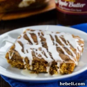 A top-down view of glazed Apple Butter Bars in a baking dish, cut into squares.