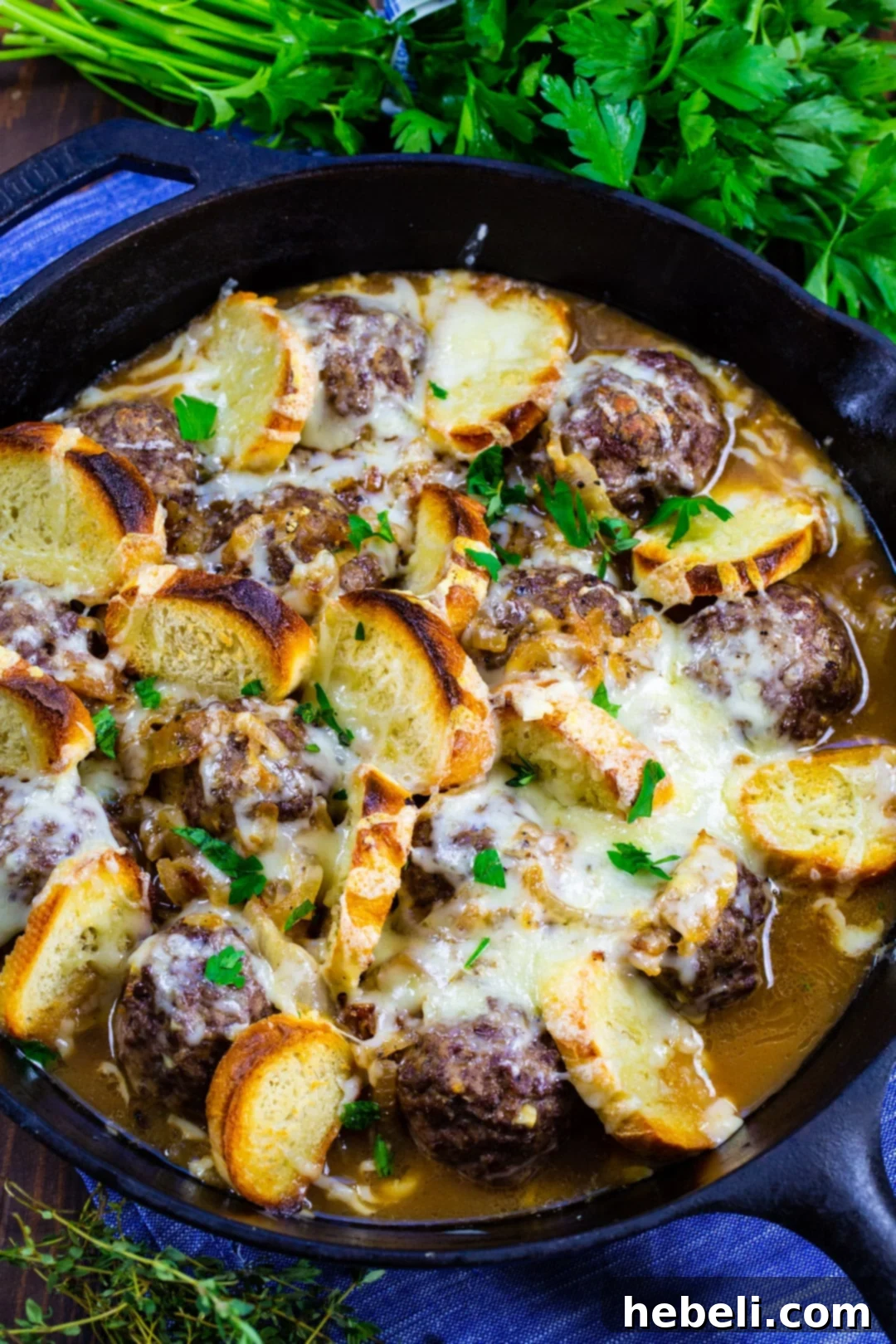 French Onion Meatballs 3 French Onion Meatballs in cast iron skillet, with melted Gruyère.
