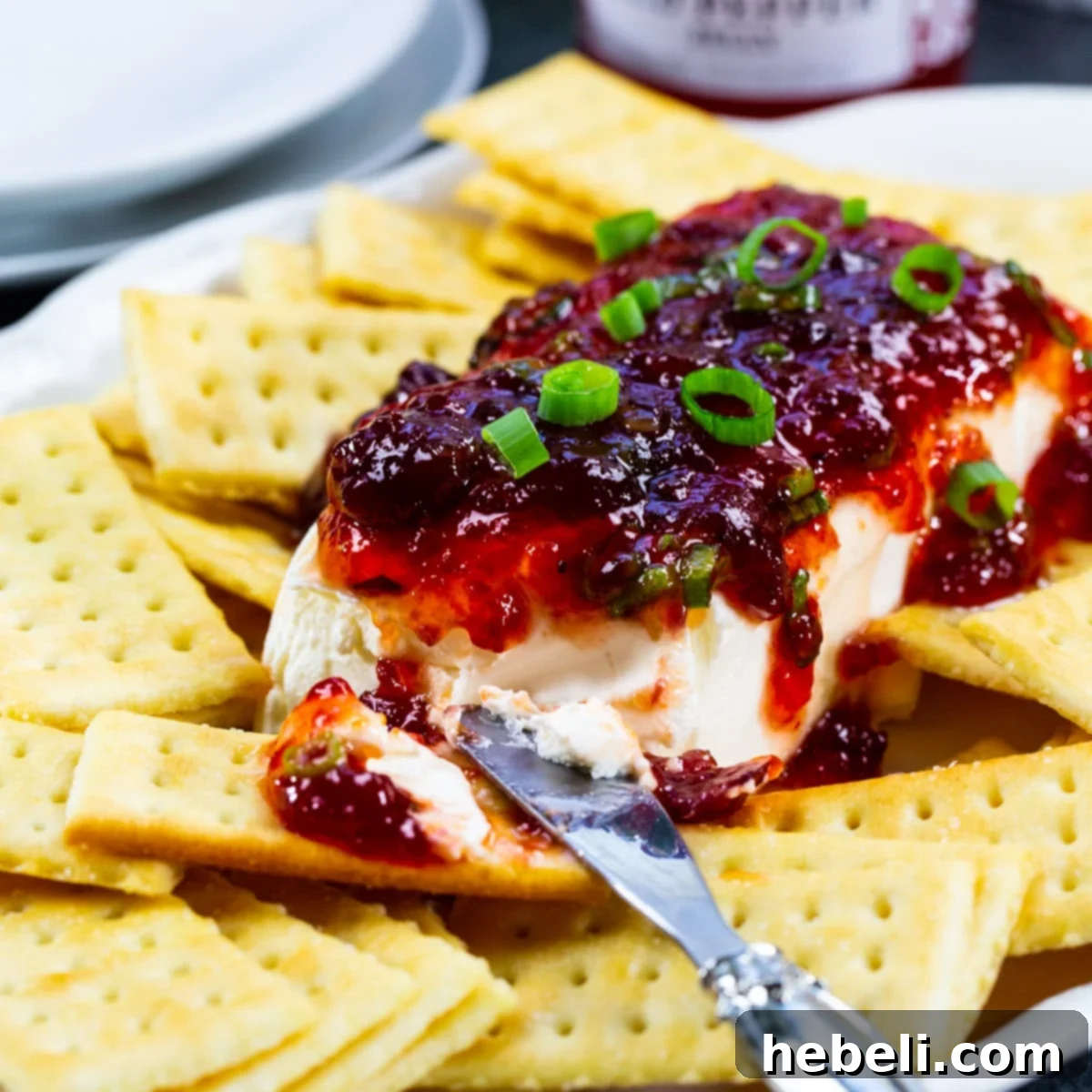 Sweet Heat Cranberry Spread 2 Cranberry Pepper Jelly Spread on a plate with Club crackers, ready to serve.
