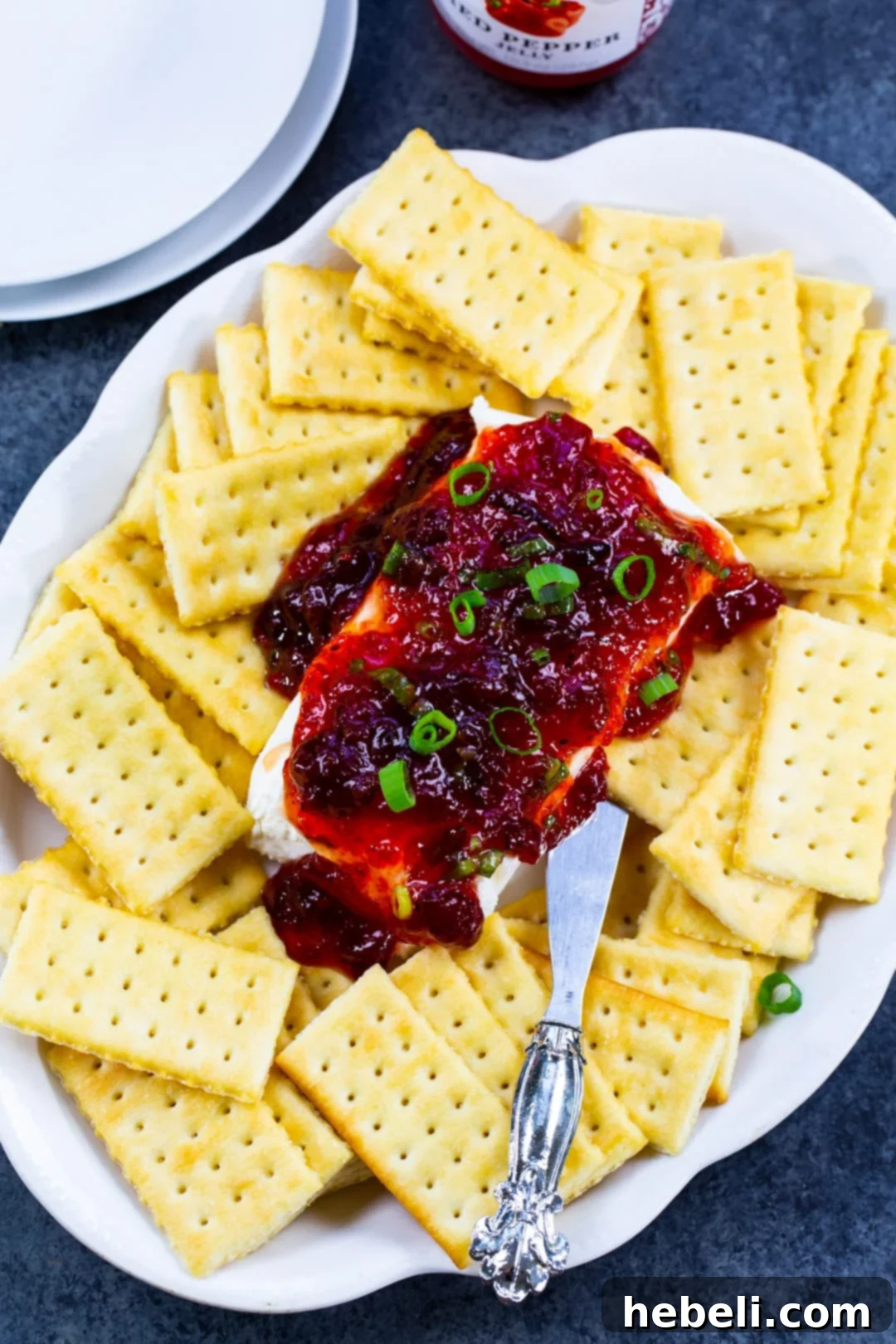 Sweet Heat Cranberry Spread 3 Close-up of Cranberry Pepper Jelly Spread elegantly layered on a block of cream cheese.