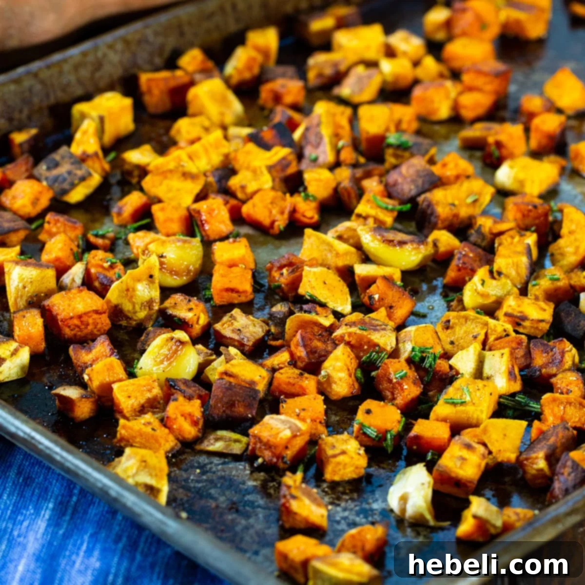 Aromatic Rosemary Garlic Roasted Sweet Potatoes 2 Beautifully roasted rosemary garlic sweet potatoes on a baking sheet, golden and caramelized.