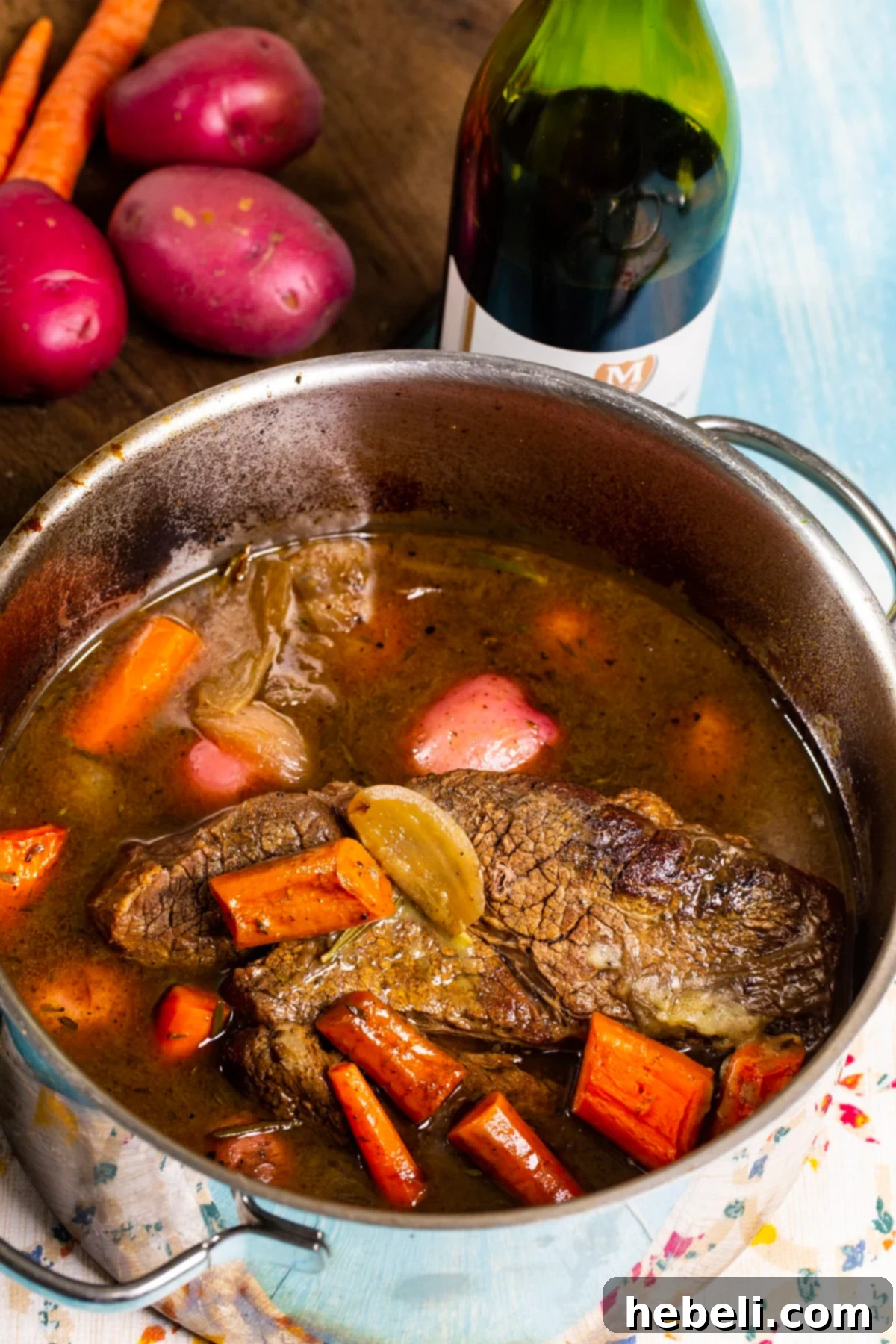 Perfectly Tender Pot Roast 3 Finished dish in a Dutch oven and bottle of wine.