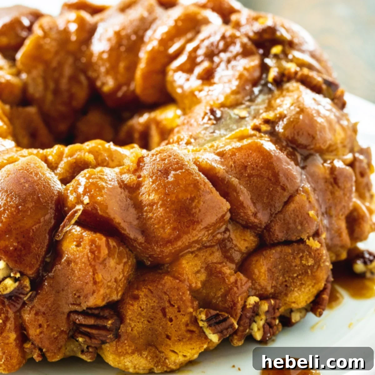 Delicious Easy Monkey Bread, golden brown and glazed, on a white serving plate, ready to be pulled apart and enjoyed.