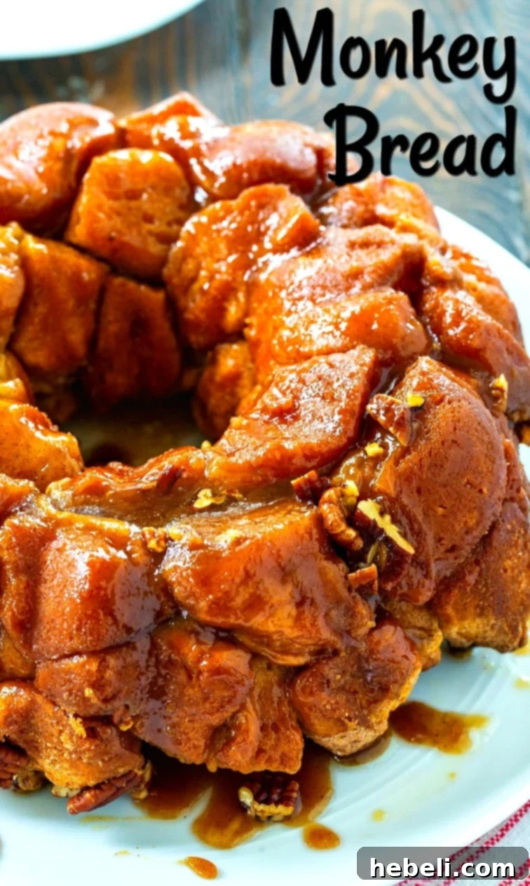 Freshly baked Easy Monkey Bread, beautifully inverted onto a decorative serving plate, showcasing its rich golden-brown crust and inviting gooey texture.