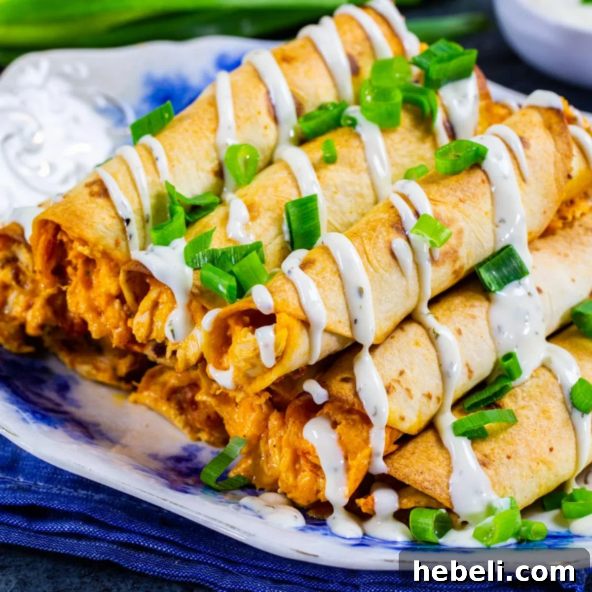 Cheesy Buffalo Chicken Taquitos Appetizer A vibrant pile of crispy Cheesy Buffalo Chicken Taquitos, golden and perfectly baked, ready for dipping.