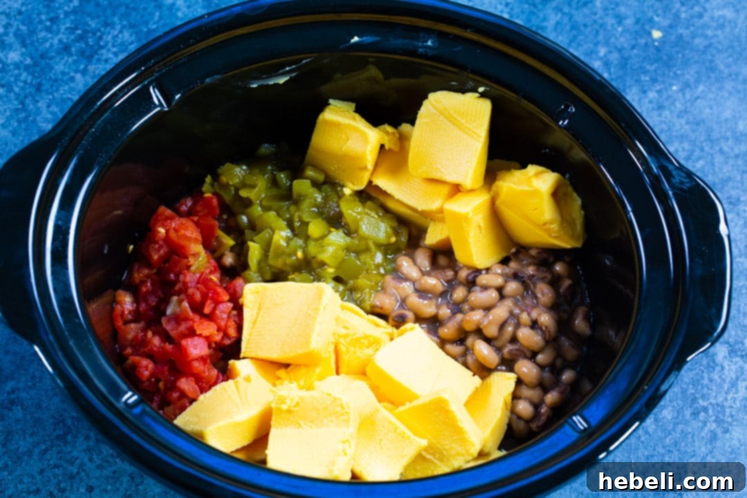 All the main ingredients for Slow Cooker Black-Eyed Pea Dip gathered in a slow cooker.