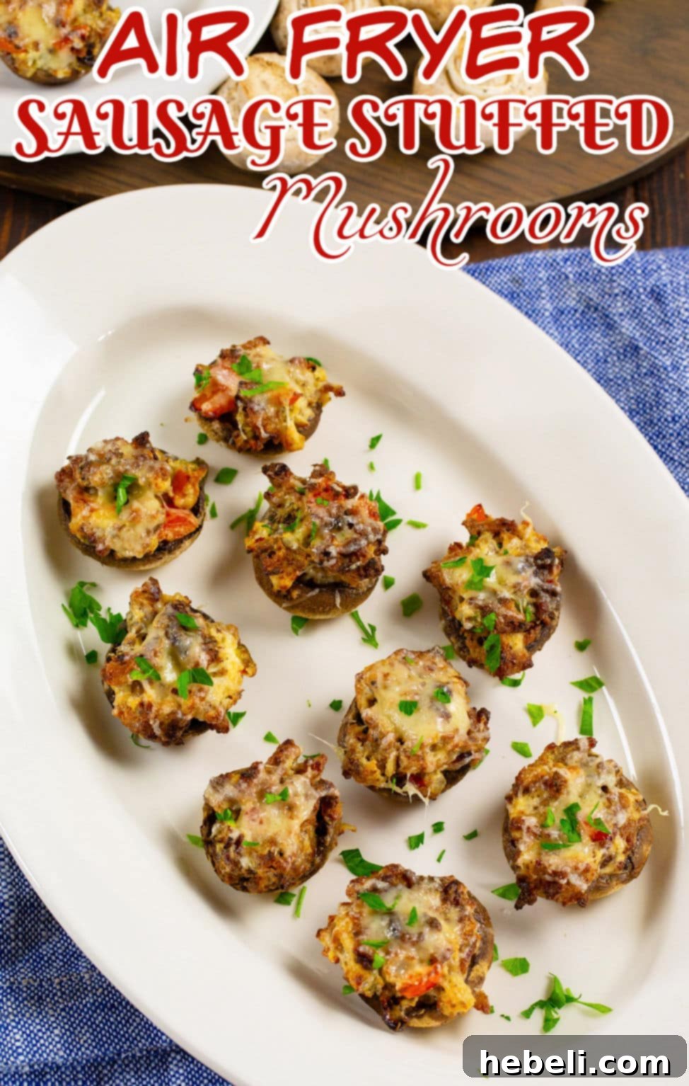 A close-up of Air Fryer Sausage Stuffed Mushrooms on a white serving plate, garnished with fresh herbs.