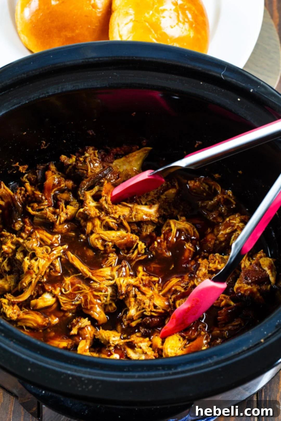 Hot Honey Chicken cooking in a slow cooker, showing the chicken simmering in the flavorful sauce.