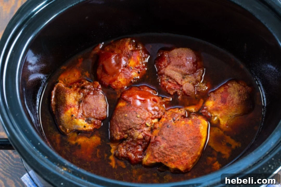 Hot Honey Chicken in the slow cooker after cooking, showing the tender, saucy chicken.