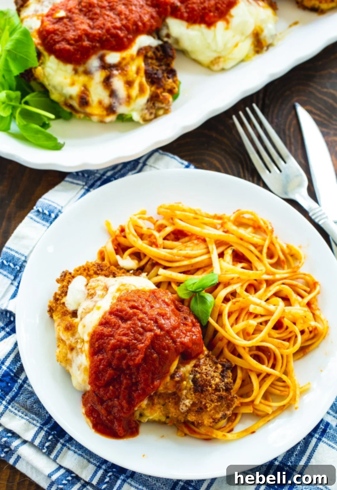 Chicken Parmesan on plate with pasta.